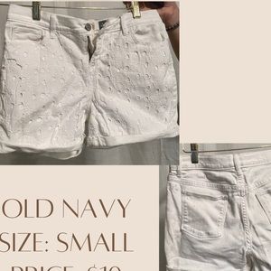 Small white jean shorts with flower pattern on the front. Pockets on both sides